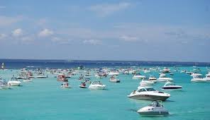 Boats spread across Crab Island turquoise waters